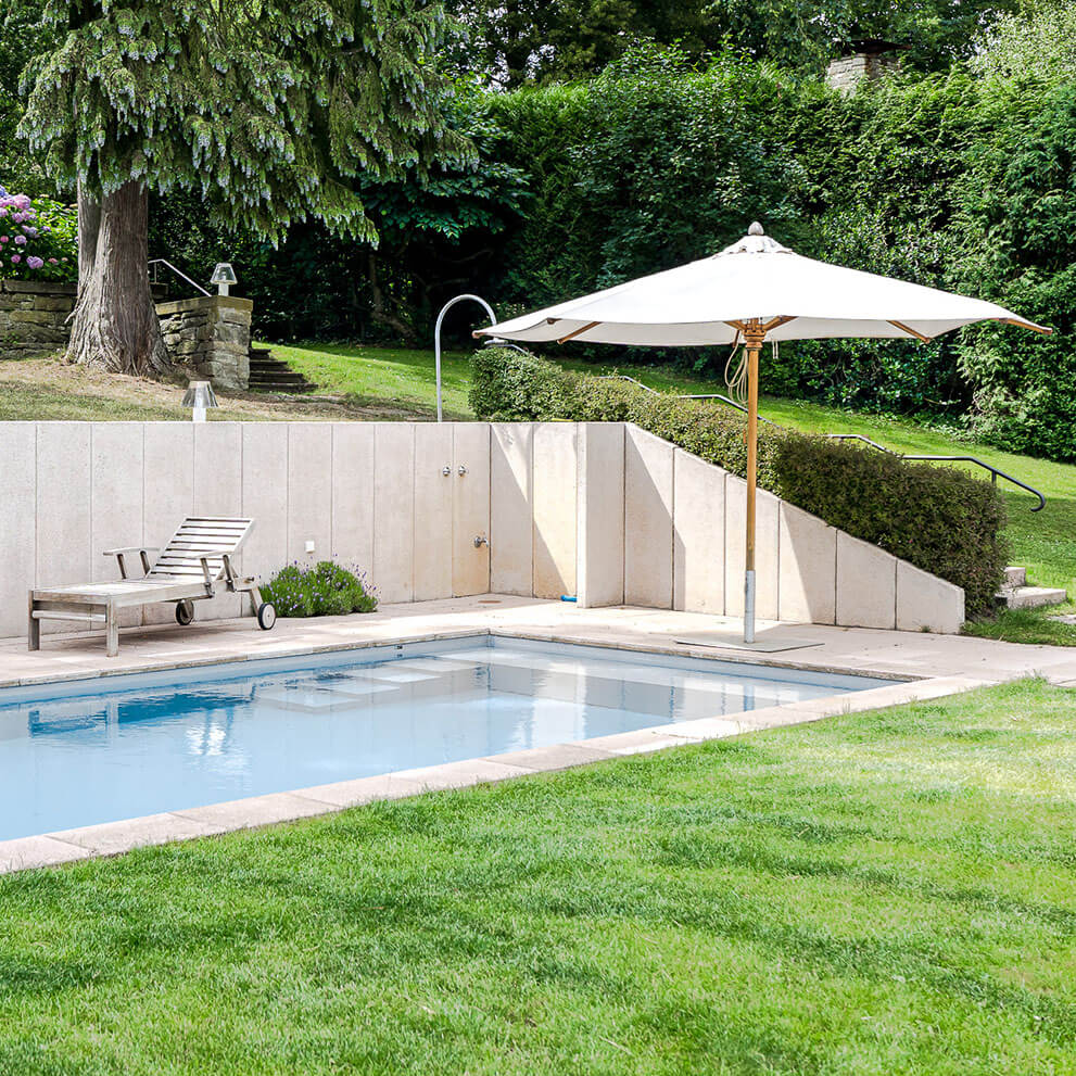 Beheizter Pool in gepflegtem Garten einer zum Verkauf stehenden Villa