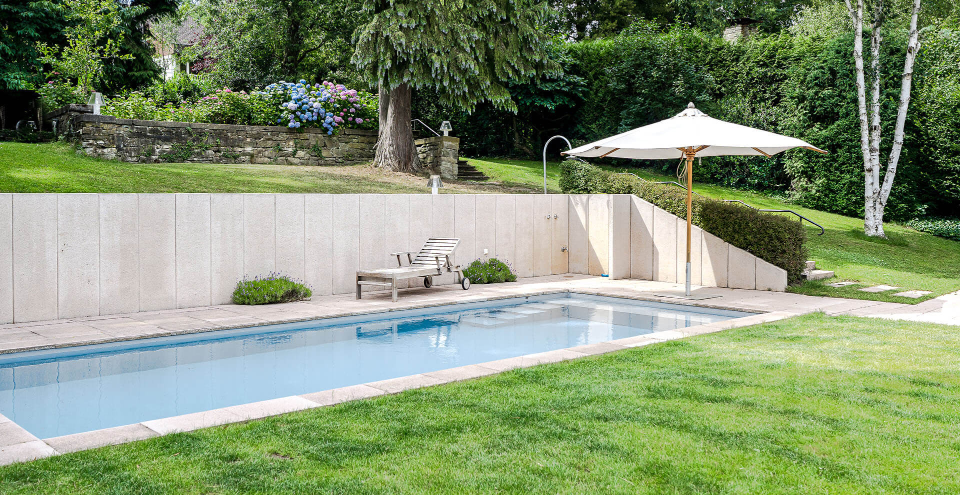 Beheizter Pool in gepflegtem Garten einer zum Verkauf stehenden Villa