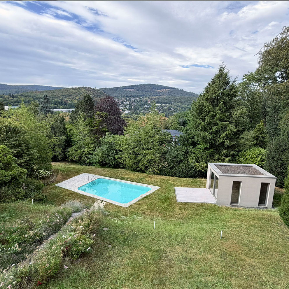 Blick auf Garten mit Poolhaus und Pool